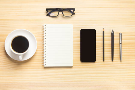 wood desk office with laptop, smartphone and other work supplies with cup of coffee. Top view with copy space for input the text. Designer workspace on desk table essential elements on flat lay.の写真素材