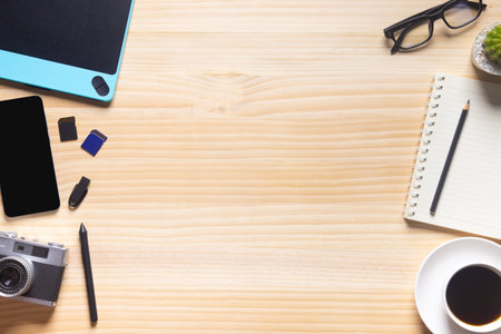 wood desk office with laptop, smartphone and other work supplies with cup of coffee. Top view with...