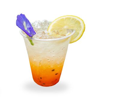 Mixing juice of lemon soda and passion fruit in glass isolated on white backgroundの写真素材