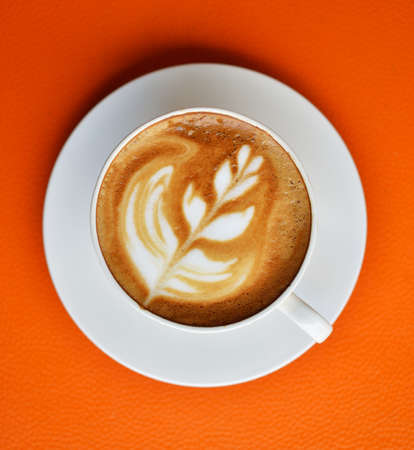 A Cup of hot latte art coffee on table