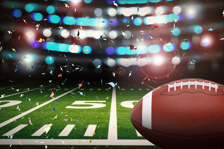 3d rendering american football ball with shining light and confetti backgroundの写真素材