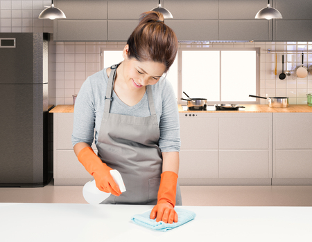 asian housekeeper cleaning on table with kitchen backgroundの写真素材