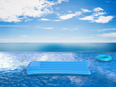 swim ring and raft on infinity pool with blue sea and blue sky