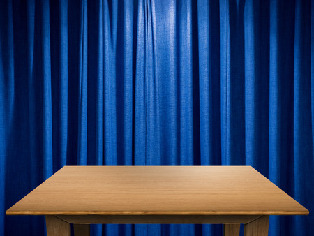 empty wooden table with blue curtain backgroundの写真素材