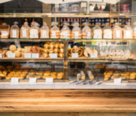 wooden counter with bakery shop blurred backgroundの写真素材
