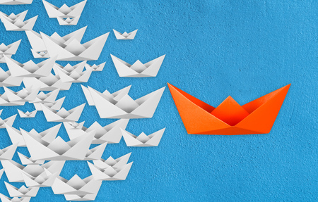 leadership concept with paper boat leading