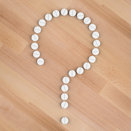 health problem concept with white pills arrange to question markの写真素材