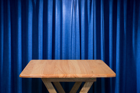 wooden table with blue curtain backgroundの写真素材