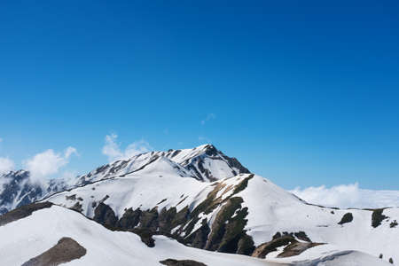 snow capped mountain landscape with blue skyの写真素材