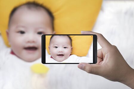 hand holding 3d rendering mobile phone taking photoの写真素材