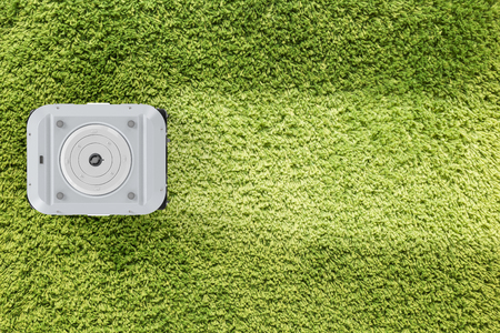 3d rendering robotic vacuum cleaner on green carpet top viewの写真素材