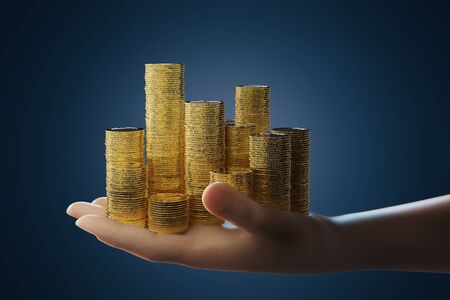 Gold investment concept with 3d rendering hand holding stack of gold coinsの写真素材