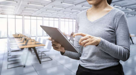 Office worker with digital tablet in office space or workspace