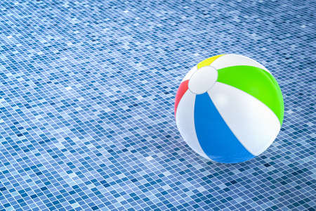 3d rendering colorful beach ball on blue tiles with space