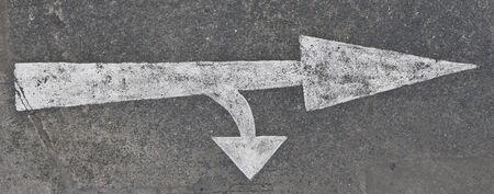 The arrow on the road. Old and chipping paintの写真素材