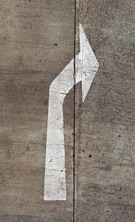 The arrow on the road. Old and chipping paint