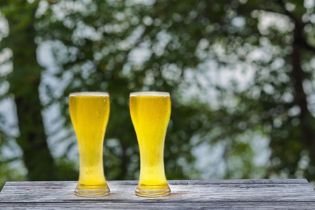 Beer in glass on a wooden table background blur.