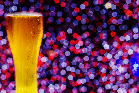 Beer in glass on a wooden table background blur.の写真素材
