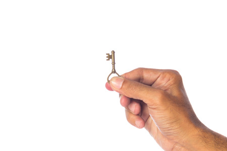 Old key in hand isolated on white background.