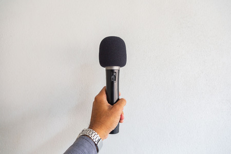 Microphone in hand on white background.の写真素材