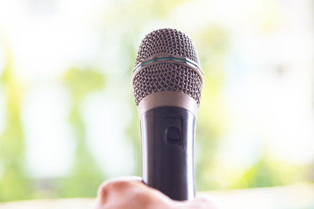Microphone in hand on white background.の写真素材