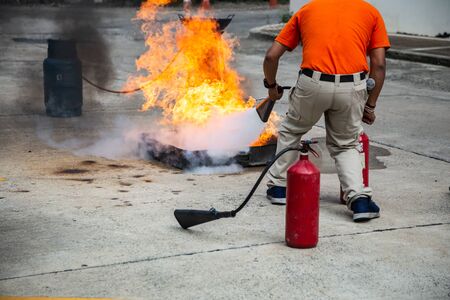 Firemen using extinguisher and water for fight fire during firef.の写真素材