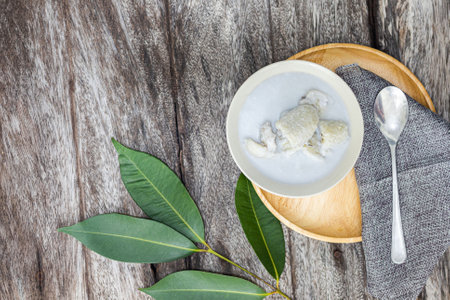 Thai dessert made from coconut milk and fresh green leaf on wooden backgroundの写真素材