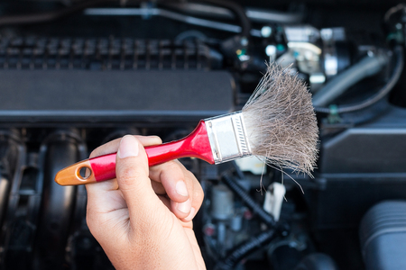 Hand holding brush for cleaning car engine.の写真素材