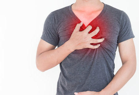 Young man has chest pain, heart attack, hands pressing on chest.の写真素材