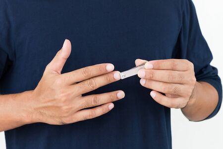 Closeup of a young man cutting nails, Health care concept.