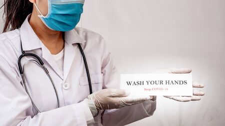 A doctor is holding wash your hand sign to motivated people to protect from Coronavirus or Covid-19 epidemicの写真素材