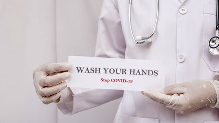 A doctor is holding wash your hand sign to motivated people to protect from Coronavirus or Covid-19 epidemicの写真素材