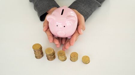 A business person is  holding piggy bank in two hands to protect saving money.の写真素材