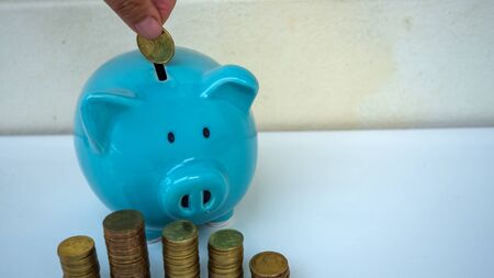 piggy bank and stake coins in wooden background. saving money for investment. copy spaceの写真素材