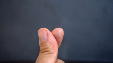 finger in heart shape in black background,