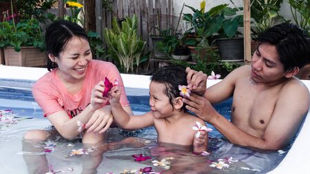 Family are relaxing in a small pool to release the heat in summer at home. Happy child, happy family, healthy family, childhood concept.の写真素材