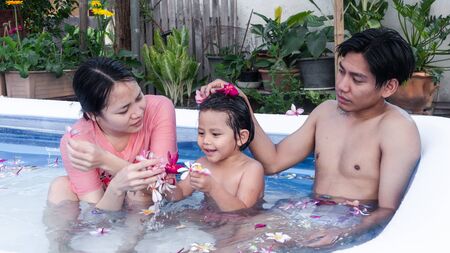 Family are relaxing in a small pool to release the heat in summer at home. Happy child, happy family, healthy family, childhood concept.の写真素材