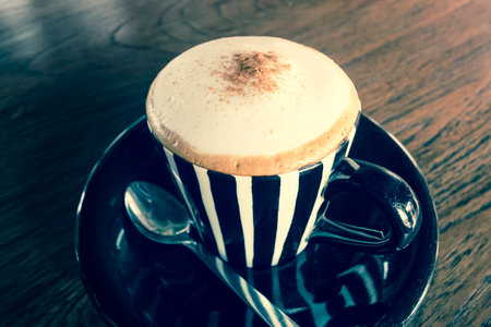 Cappuccino in an old classic cup on a wooden table - vintage effectの写真素材
