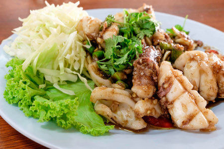 Fried squid with black pepper and garlic on white dish, Thai food