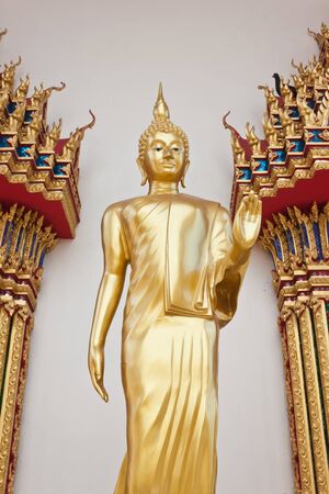 standing buddha in front of buddhist s churchの写真素材