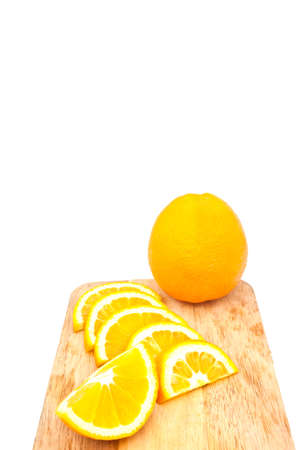 orange on chopping block over white paperの写真素材