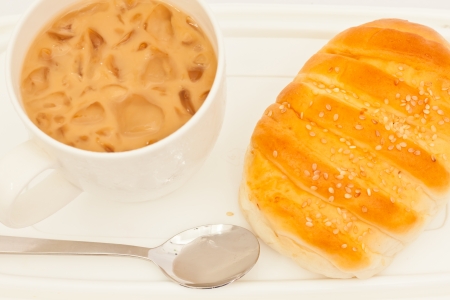 Appetizing bread and cup of ice tea on white paperの写真素材