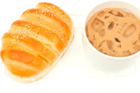 Appetizing bread and cup of ice tea on white paperの写真素材