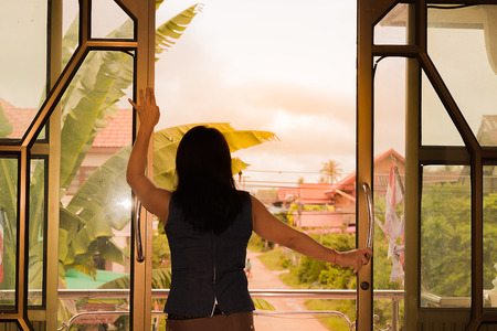 the lady stand at window look  outsideの写真素材