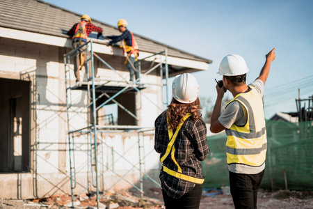 Designers and Construction Engineers Reading Worksheets near Construction Siteの写真素材