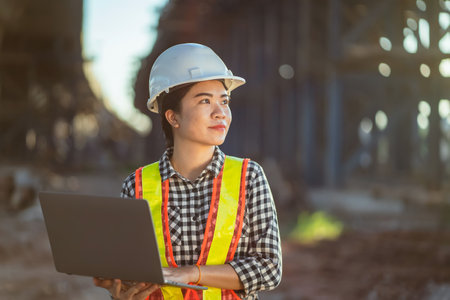 A Female Foreman Inspecting Objects at New Concrete Road and Bridge Construction Site, road Traffic is Critical Infrastructure.の写真素材