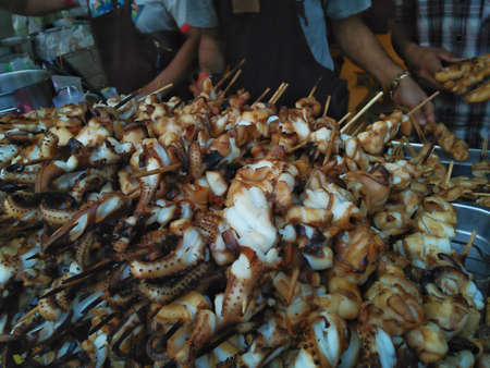 Close-up of grilled squids, street food. Selective focus at squids.