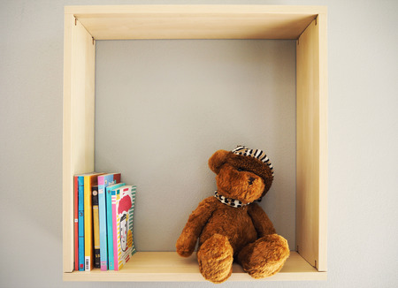 Teddy bear sit on bookshelfの写真素材
