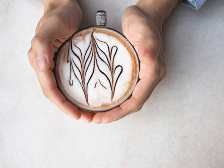 A cup of coffee in handsの写真素材