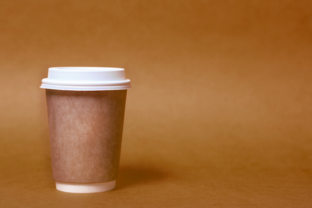Paper cup for coffee on a brown backgroundの写真素材